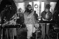 a group of people playing instruments in front of a house